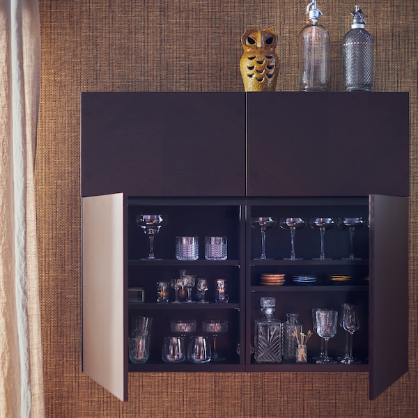 A BESTÅ wall cabinet with HEDEVIKEN doors. Two doors are open, showing glasses, coasters and cocktail-making accessories.