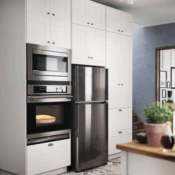 A kitchen with white cabinet fronts and stainless steel appliances.