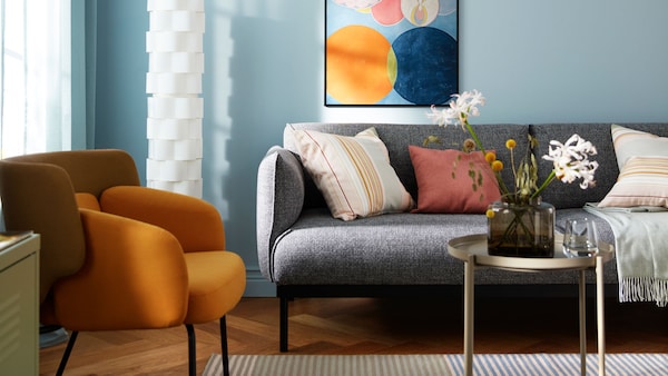 A light blue sofa with colorful cushions on top.
