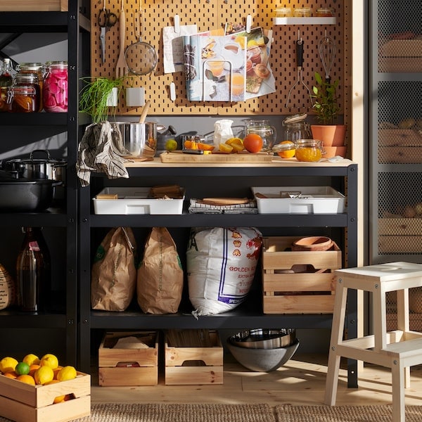 A pantry with an entire wall with shelves, cabinets and boxes dedicated to storing a variety of food and cooking items.