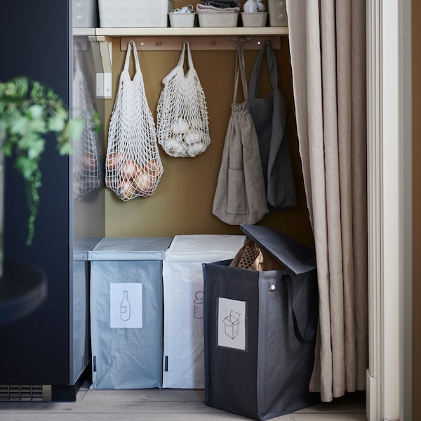 A recycling station with three DIMPA waste-sorting bags, shelves and KUNGSFORS net bags placed in a recess behind a curtain.