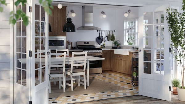 A SEKTION kitchen with a NORDVIKEN extendable table in white, white NORDVIKEN chairs and two black SVARTNORA pendant lamps.