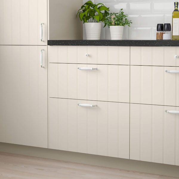 A set of kitchen cabinets in white with a black stone countertop.