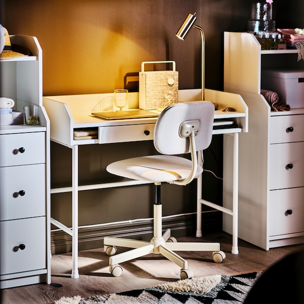 A white HAUGA desk and a beige swivel chair in between two HAUGA chests of 3 drawers with shelf.