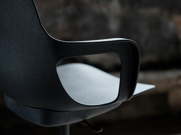 An anthracite ODGER swivel chair standing in a dimly lit room.