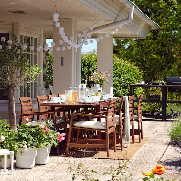 An outdoor table and chair set with a grill nearby.