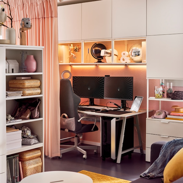 An UTESPELARE gaming chair and desk surrounded by a white PLATSA storage combination holding gaming and other accessories.