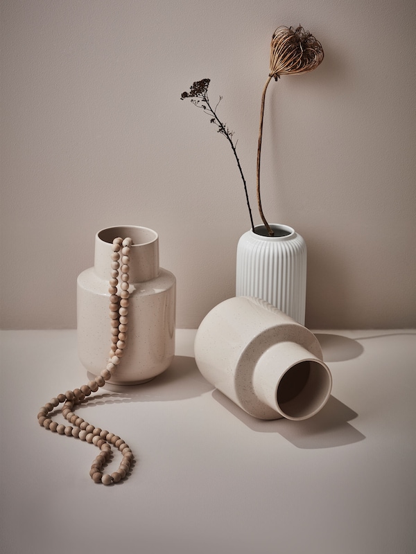 Ceramic modern decor vases with wooden beads and dried flowers. 