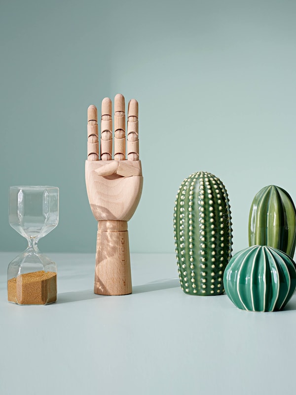 Modern home decor decorative items: an hourglass, wooden flexible hand & plant figurines. 