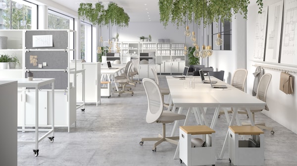 A large open-plan office with furniture from the TROTTEN system including desks and storage units on castors.