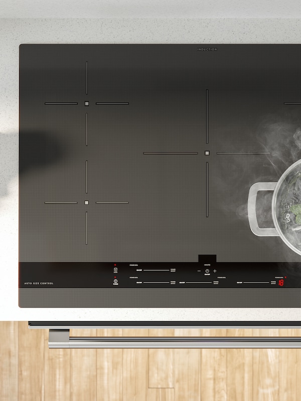 A SÄRDRAG induction cooktop with a stainless steel pot boiling vegetables in the corner.