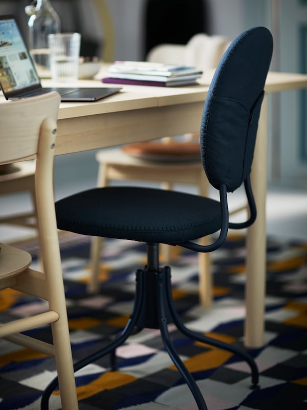 A blue BJÖRKBERGET swivel chair stands between RÖNNINGE birch chairs by a RÖNNINGE birch table, all placed on a TÅRBÄK rug.