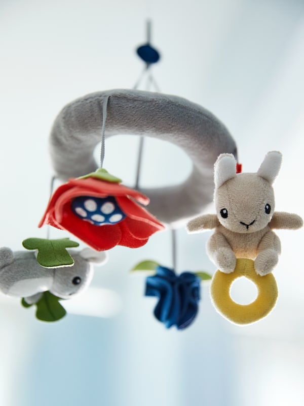 A multicolor GULLIGAST mobile with various hanging imaginary animal figures and flowers hangs from the ceiling.