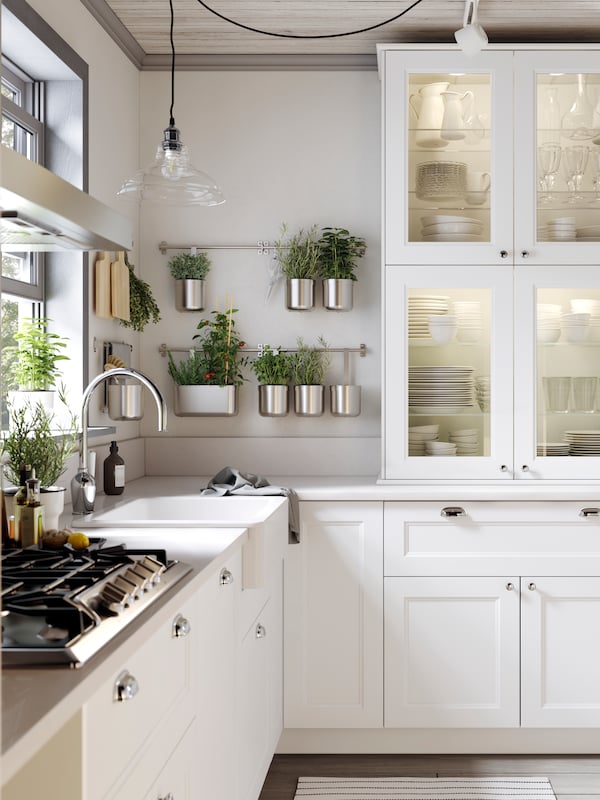 An open plan white SEKTION kitchen with a HAVSEN sink bowl in white and a gas cooktop in stainless steel.