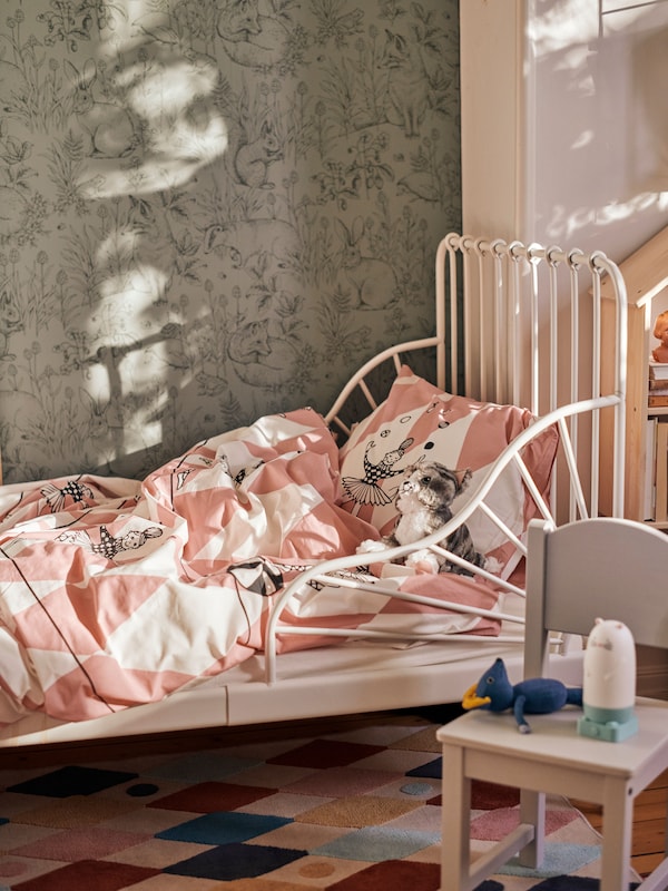 A child's room with a SPIKEN otter-shaped LED night light and a white MINNEN extendable bed made with BUSENKEL bed linen.