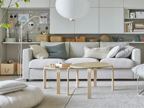 SVALSTA nest of tables, a set of two, on two SPORUP rugs lying together in front of a sofa under a RISBYN pendant lamp.